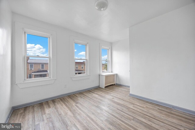 spare room with radiator and light hardwood / wood-style flooring