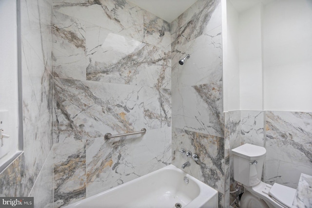 bathroom with tiled shower / bath, tile walls, and toilet