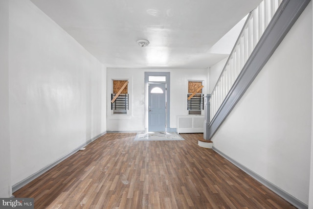 entryway featuring baseboards, stairway, and wood finished floors