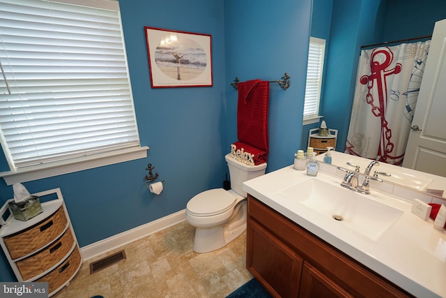 bathroom featuring a healthy amount of sunlight, toilet, and vanity