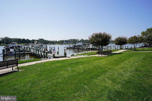 view of dock with a water view and a lawn