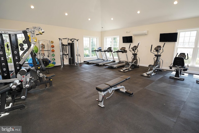 exercise room with lofted ceiling, a wealth of natural light, and a wall unit AC