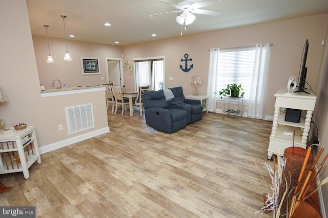 living room with ceiling fan and light hardwood / wood-style floors