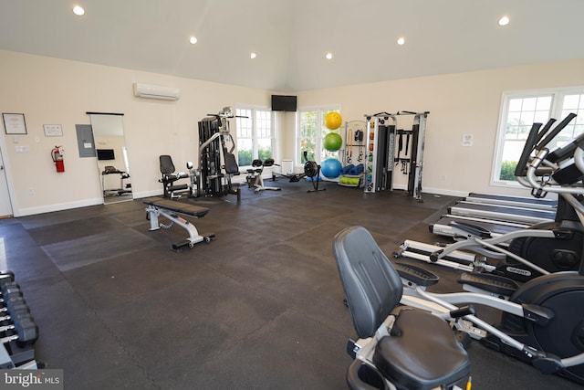 exercise room featuring a wall mounted air conditioner and vaulted ceiling