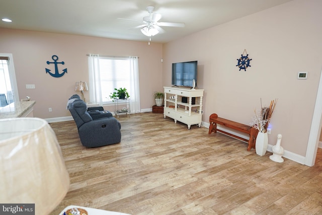 living area with ceiling fan and light hardwood / wood-style floors