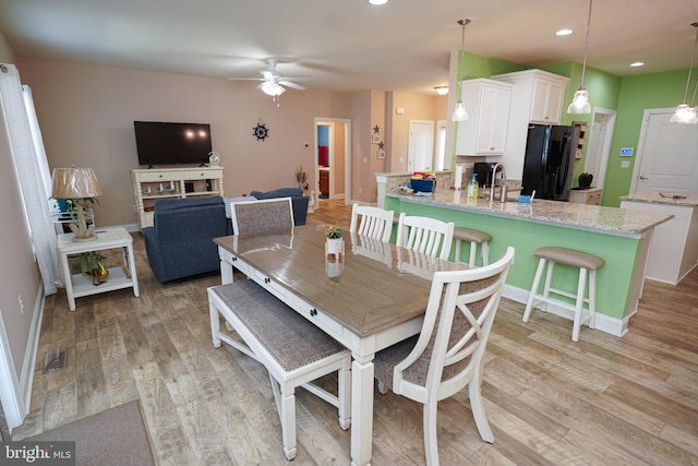 dining space featuring light hardwood / wood-style flooring, sink, and ceiling fan