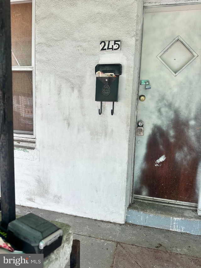 doorway to property featuring stucco siding