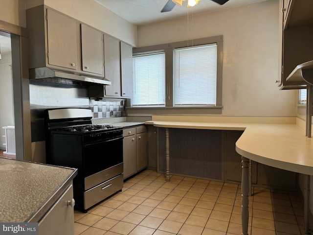 kitchen with gas range, light tile patterned floors, ceiling fan, and decorative backsplash