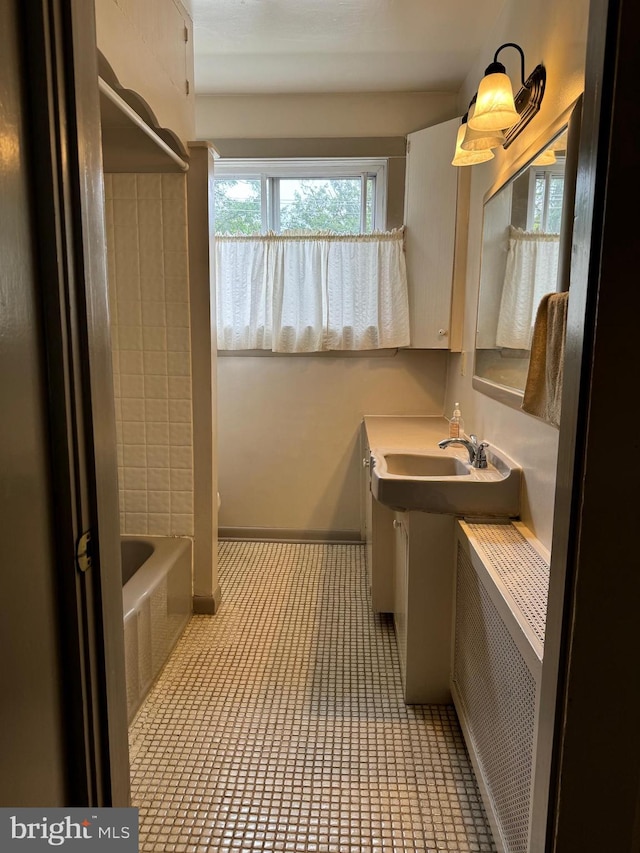 bathroom featuring tile patterned flooring, sink, radiator heating unit, and a washtub