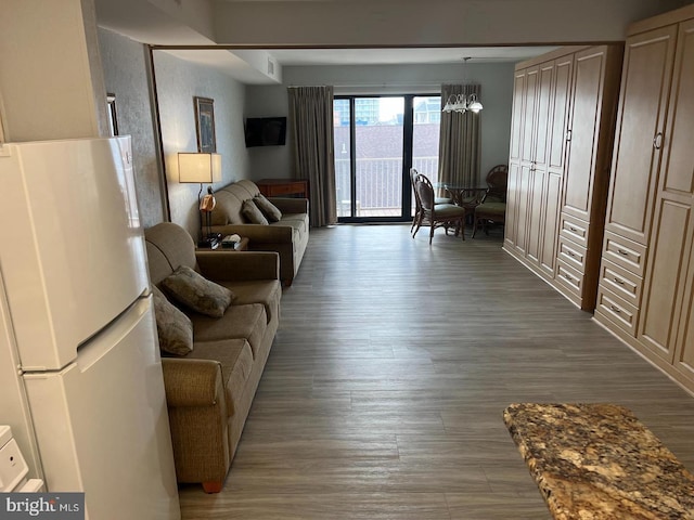 living room featuring hardwood / wood-style flooring and an inviting chandelier