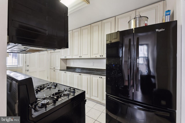 kitchen featuring black refrigerator, light tile patterned floors, extractor fan, and range