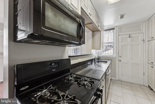 kitchen featuring white cabinets, light tile patterned floors, sink, and black appliances