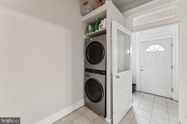 clothes washing area with light tile patterned floors and stacked washer and clothes dryer