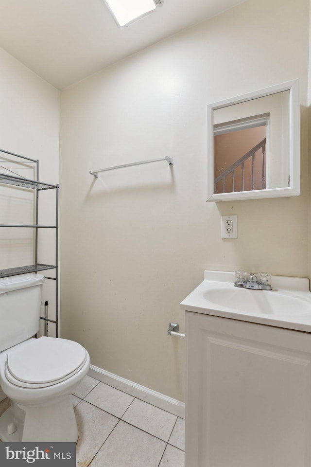 bathroom featuring tile patterned flooring, vanity, and toilet