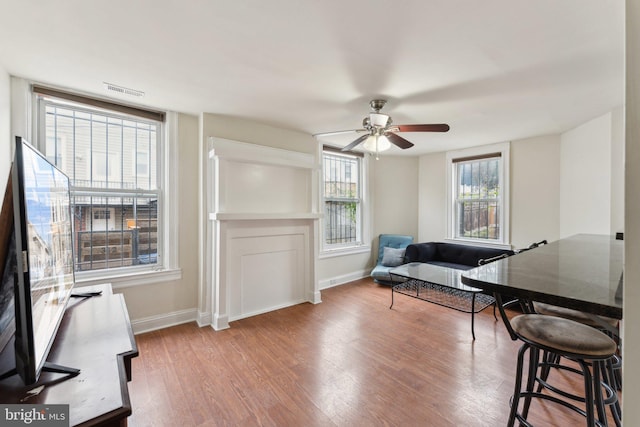 home office with ceiling fan, baseboards, and wood finished floors