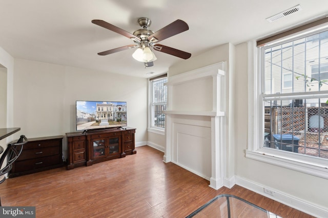 interior space featuring visible vents, ceiling fan, baseboards, and wood finished floors