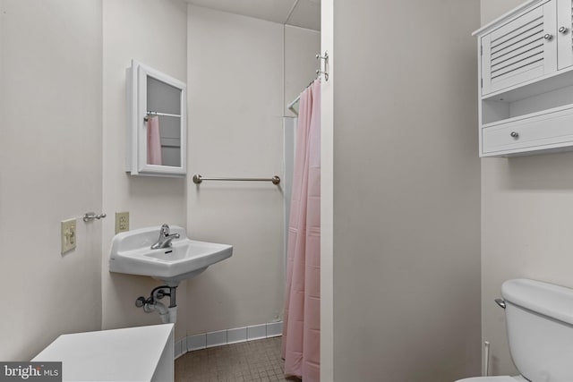 bathroom featuring walk in shower, tile patterned flooring, and toilet