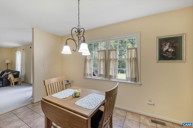 carpeted dining space with an inviting chandelier