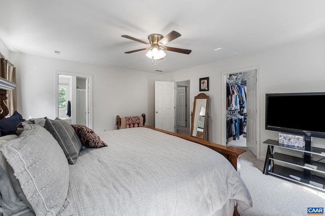 bedroom featuring a closet, ceiling fan, a spacious closet, and light carpet