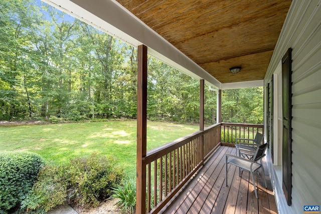 wooden terrace featuring a porch and a yard