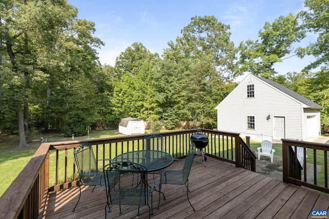 wooden deck with a storage unit and a lawn