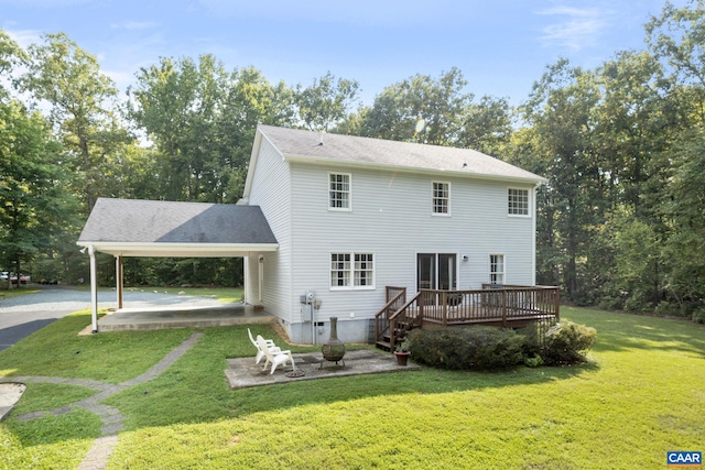 back of property with a patio area, a yard, a carport, and a deck