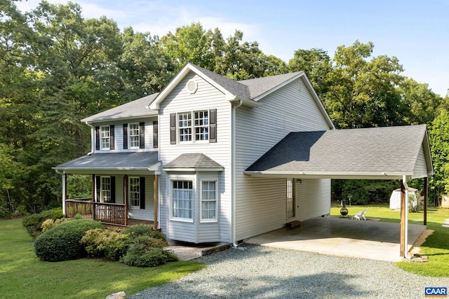 view of front of home with covered porch, a shed, a carport, and a front lawn