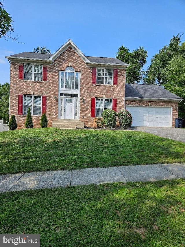 colonial inspired home featuring a garage and a front yard