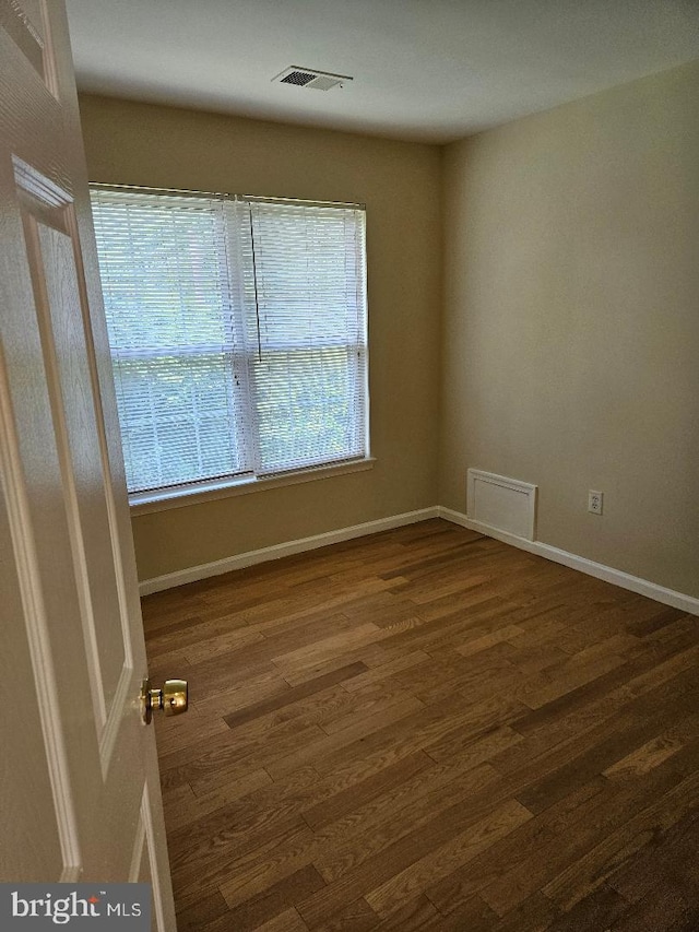 unfurnished room with dark wood-type flooring