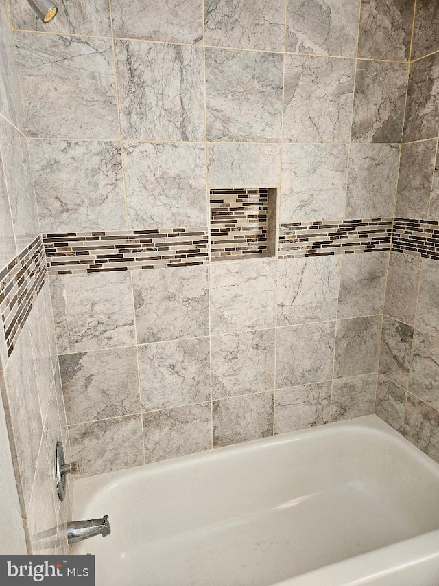 bathroom featuring tiled shower / bath