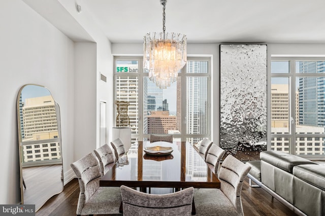 dining area featuring dark hardwood / wood-style floors and an inviting chandelier