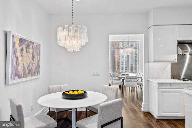 dining area with a notable chandelier and dark hardwood / wood-style floors