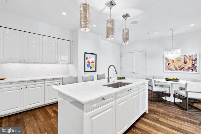 kitchen with pendant lighting, dark hardwood / wood-style floors, white cabinets, and sink