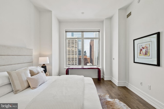 bedroom with dark hardwood / wood-style flooring