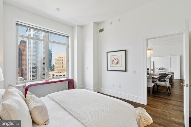 bedroom with dark hardwood / wood-style flooring