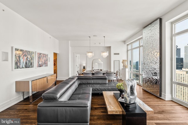 living room with hardwood / wood-style flooring, plenty of natural light, and an inviting chandelier