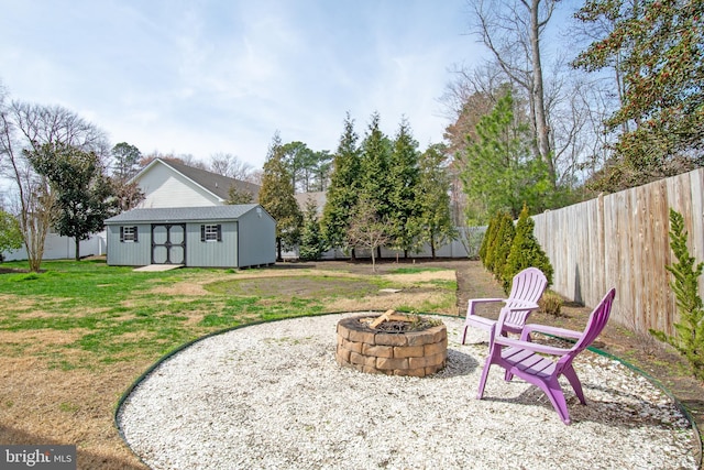 view of yard with a storage shed, fence, an outdoor structure, and an outdoor fire pit