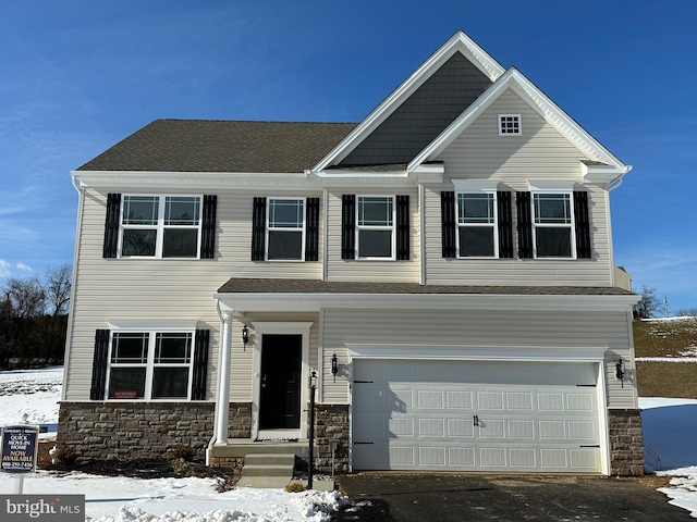 view of front of property with aphalt driveway, stone siding, roof with shingles, and an attached garage