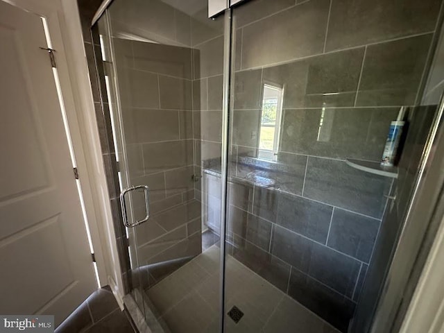 bathroom featuring a shower with door