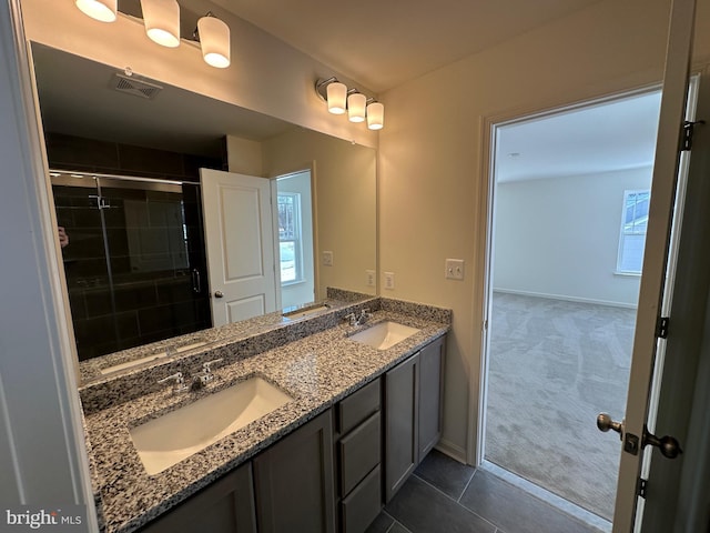 bathroom featuring vanity, tile patterned floors, and walk in shower