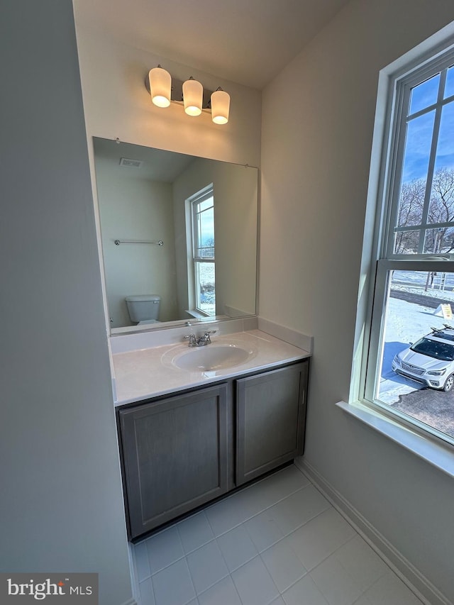 bathroom featuring vanity, toilet, and a wealth of natural light