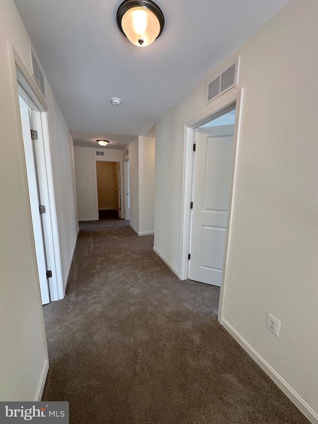 hallway with dark colored carpet