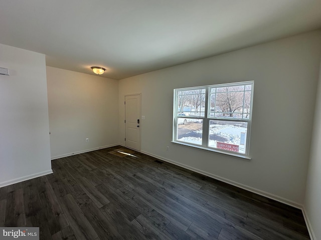 unfurnished room with dark wood-type flooring