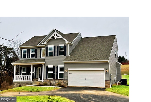 view of front facade with aphalt driveway, central air condition unit, covered porch, and an attached garage