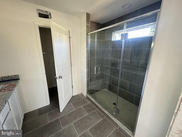 bathroom featuring vanity, walk in shower, and tile patterned floors