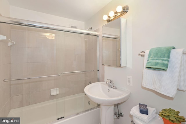 bathroom featuring bath / shower combo with glass door