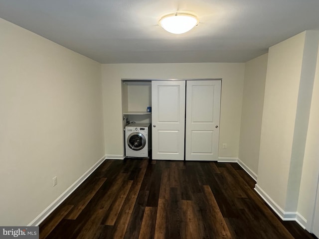 clothes washing area with washer / dryer, dark hardwood / wood-style flooring, and cabinets