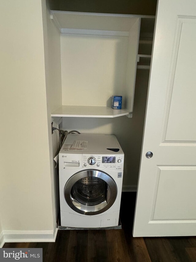 clothes washing area featuring dark hardwood / wood-style flooring and washer / dryer