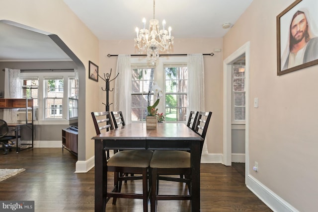 dining space with dark wood-type flooring and a notable chandelier