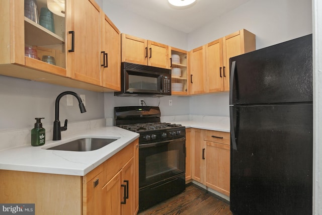 kitchen with light brown cabinetry, light stone counters, dark hardwood / wood-style flooring, sink, and black appliances